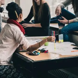 Fünf Menschen sitzen bei einem Meeting in lockerer Stimmung